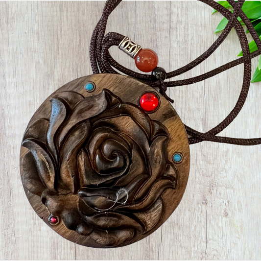 A carved rose pendant in sunken wood